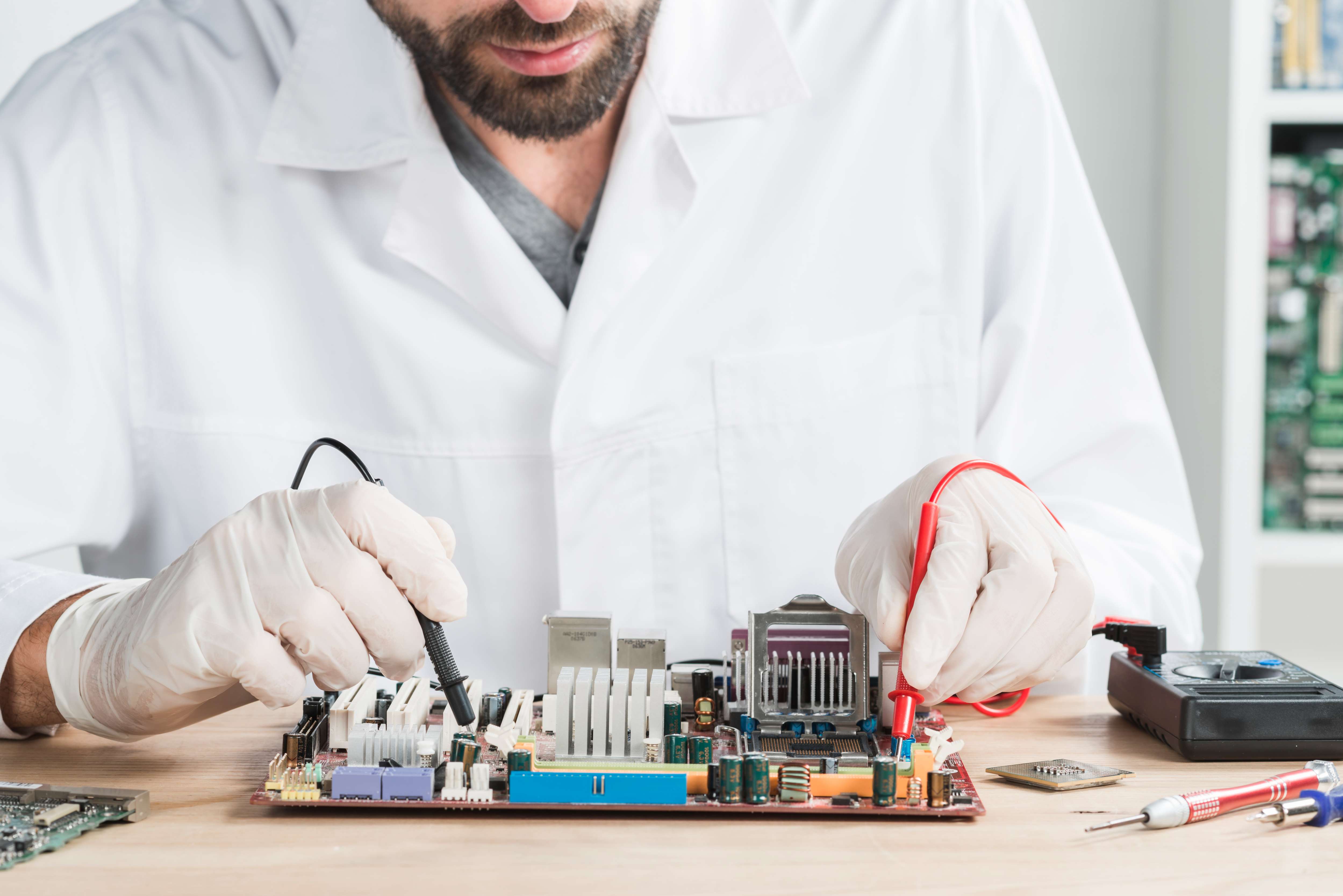 Technicien Flexitronic vérifiant une carte électronique au multimètre